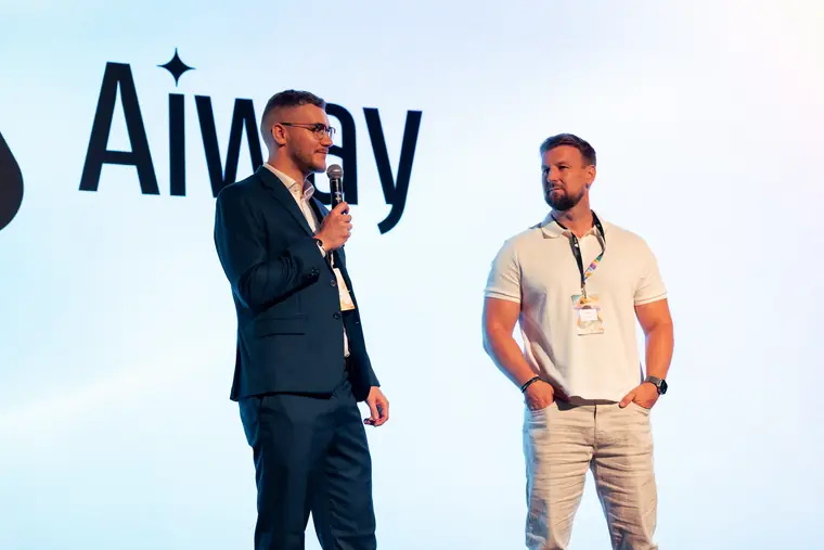 Řečník před logem AIWAY na pódiu